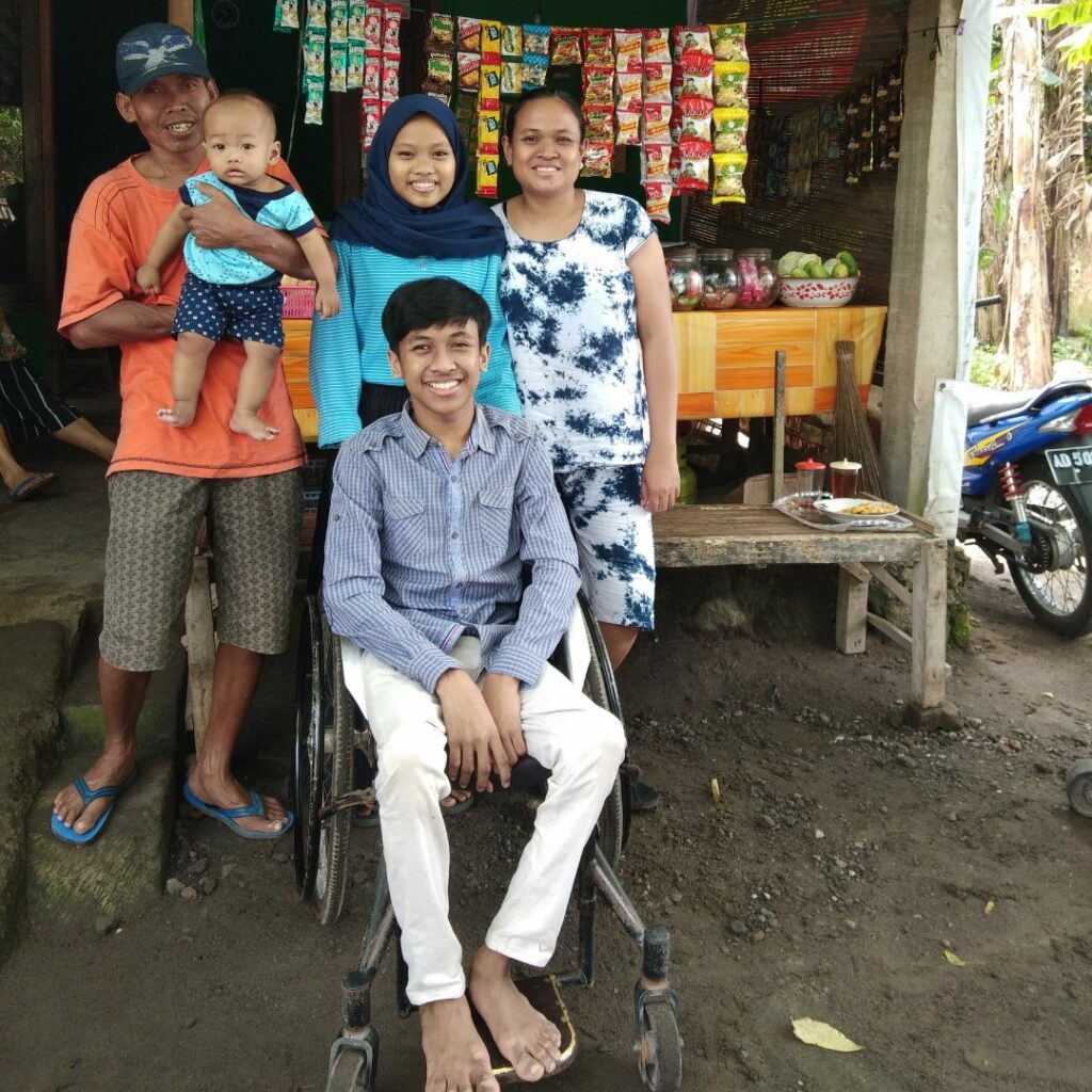 Danar in a wheelchair with his family